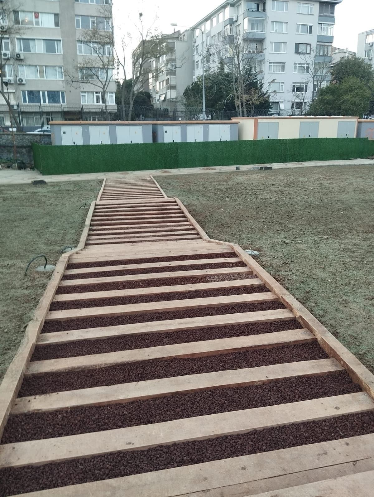 Eğimli çim bahçede basamaklı yürüyüş yolu