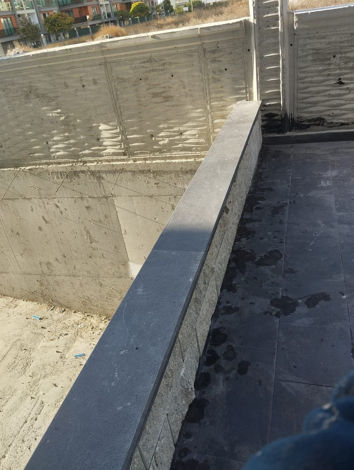 Teras zemininde koyu renk granit plaka kaplama ve parapet üzerinde granit kapak taşı